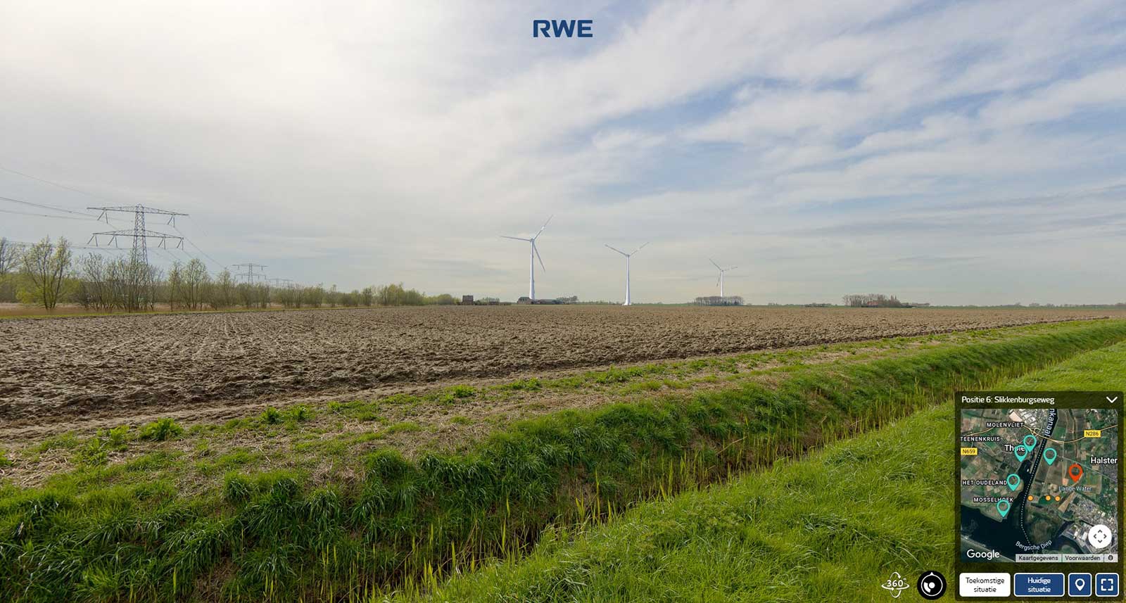 Een panoramisch uitzicht op een omgeploegd veld met windturbines op de achtergrond onder een bewolkte lucht.